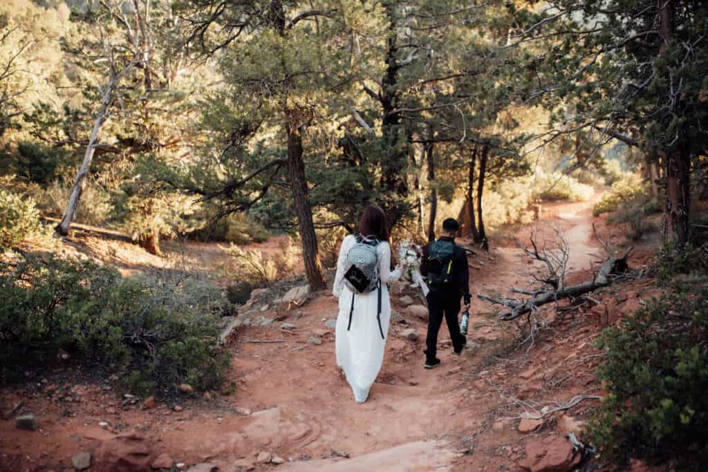 Adventure elopement in Arizona - couple hikes in their wedding clothes to their elopement location in Sedona, AZ